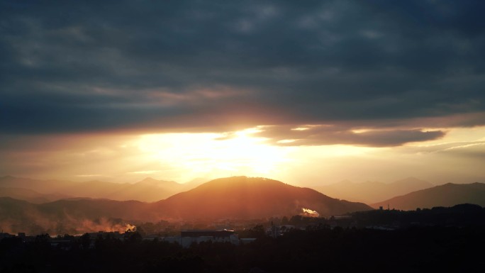 傍晚乡村烟雾山峰天空阳光穿透云朵日落延时