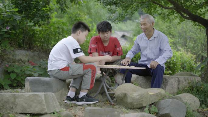 4K滑轨拍摄古村落古树下下棋的爷孙两代人