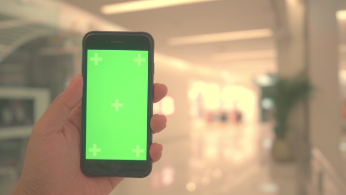 手持绿色屏幕手机手机APP科技应用购物消