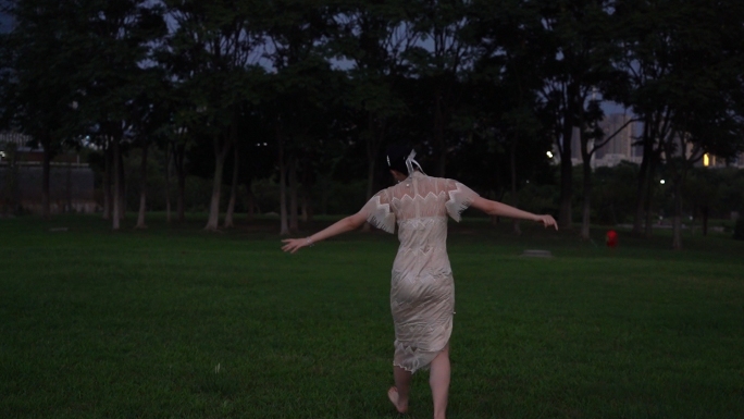旗袍美女在草地跳舞