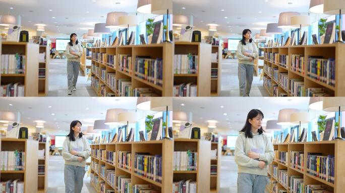 年轻女子图书馆书架前边走边查找书本
