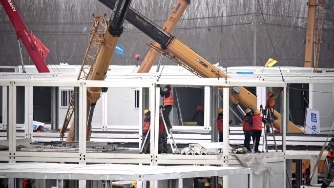 航拍建筑工地工人吊车吊装彩钢房集装箱方舱