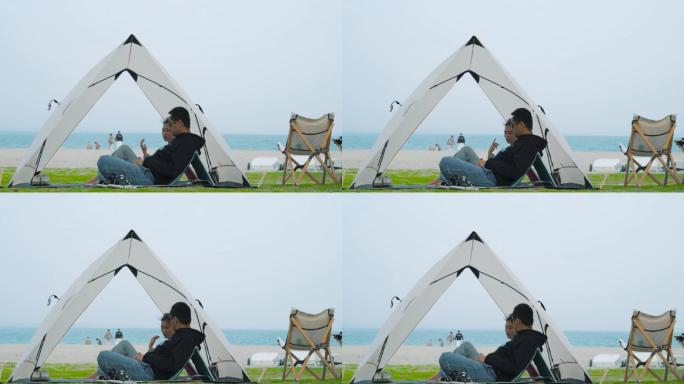 在海边帐篷里聊天的情侣