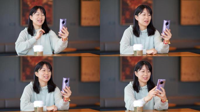 年轻女子在咖啡店使用手机视频通话