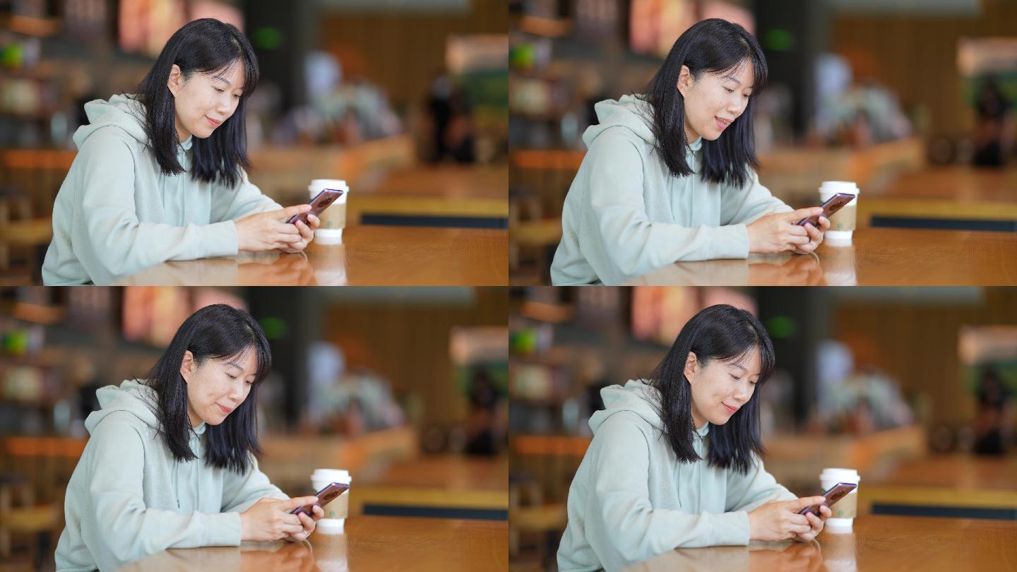 年轻女子在咖啡店使用手机刷朋友圈
