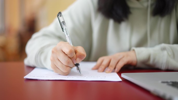 年轻女子在图书馆学习拿笔记录