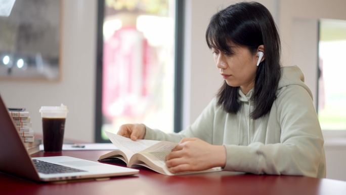 年轻女子在图书馆翻书查阅资料