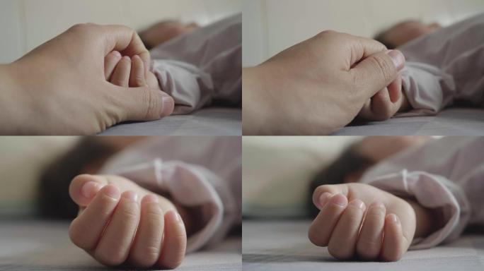 母亲紧紧的握住宝宝的手