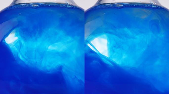 圆形玻璃中的蓝色颜料水中扩散