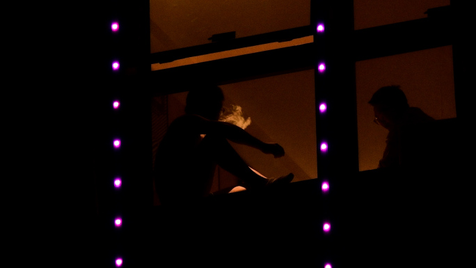 男人窗边抽烟消愁剪影