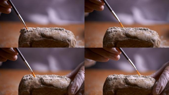 考古人员用刷子轻轻扫除文物上的灰土