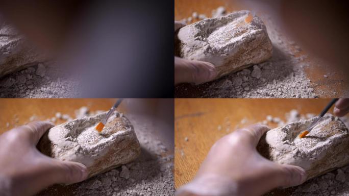 考古人员用刷子轻轻扫除文物上的灰土