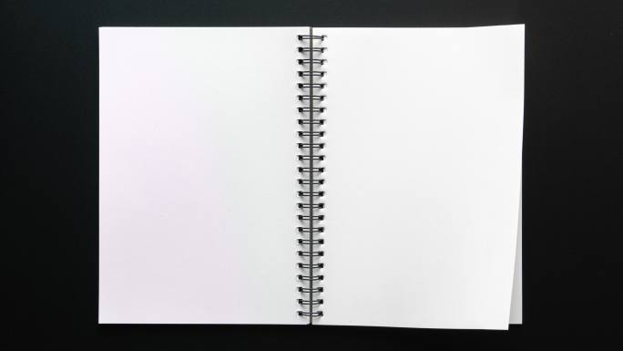 在黑色背景上打开空白页的笔记本
