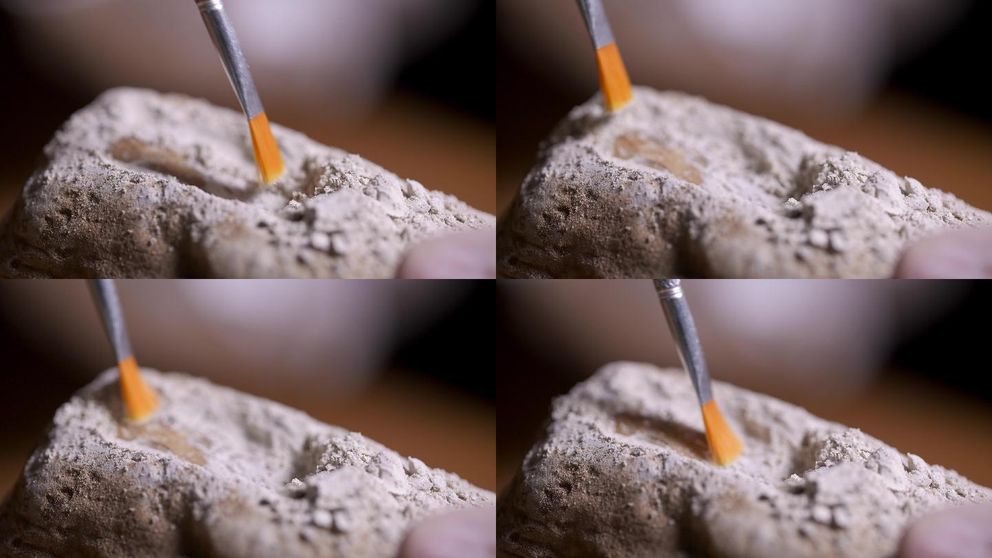 考古人员用刷子轻轻升格扫除文物上的灰土