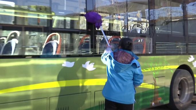 公交公司员工清洁工清洗公交车窗户车体