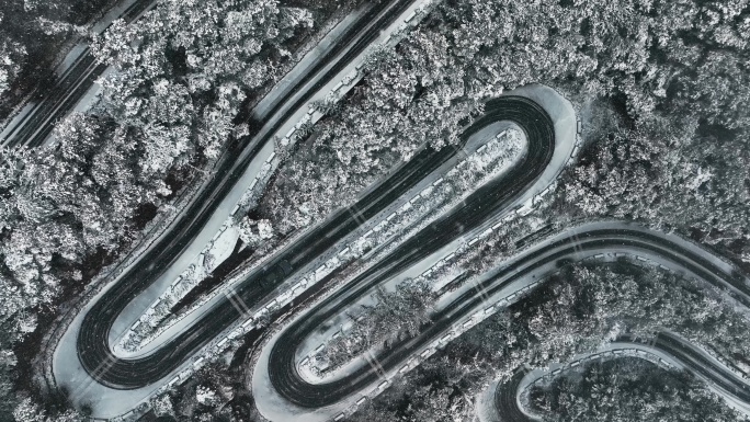 汽车行驶在盘山公路雨雪天航拍