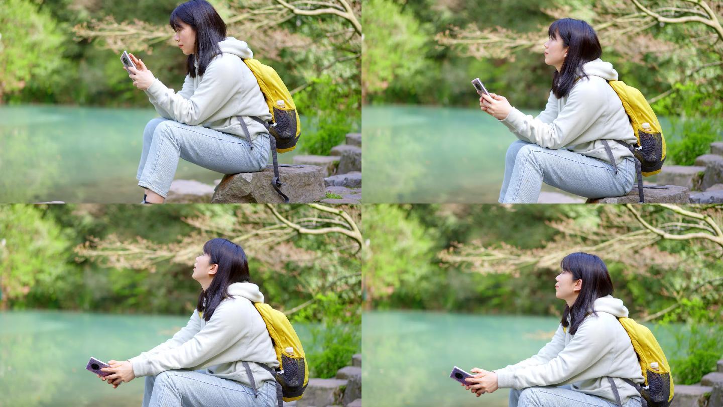 春天年轻女孩在池塘边玩手机刷手机刷朋友圈