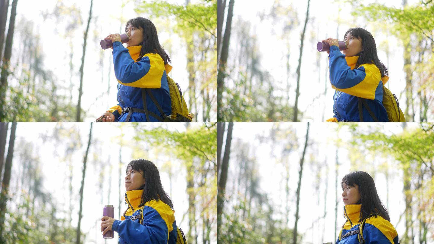 春天公园里游玩的年轻女孩拿起水杯喝水