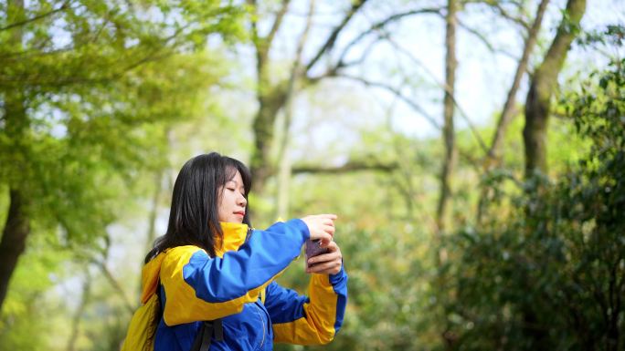 年轻女孩公园使用手机拍照刷朋友圈刷视频