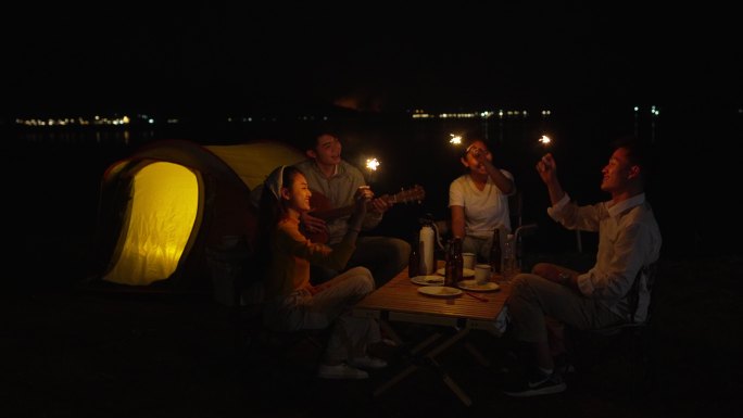 一群朋友野营时在海滩上玩火花
