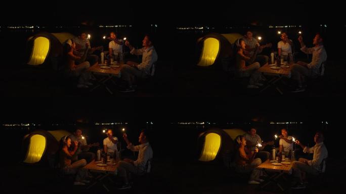一群朋友野营时在海滩上玩火花