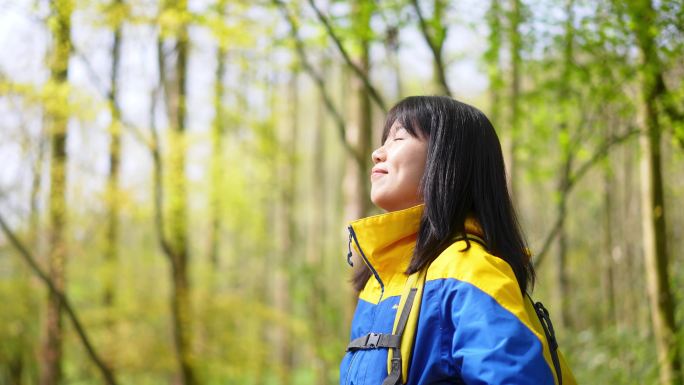 春天年轻女孩在公园里驻足抬头闭目深呼吸