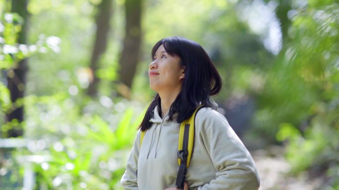 春天年轻女孩郊游公园山林小道抬头欣赏美景