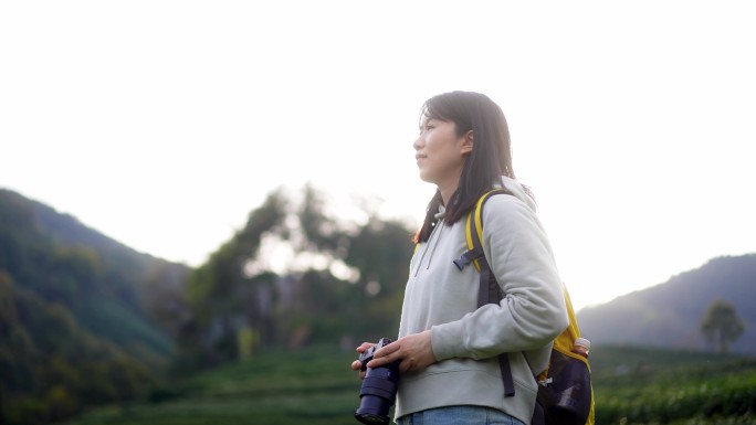 春天年轻女孩郊游公园拿相机拍摄美丽景色