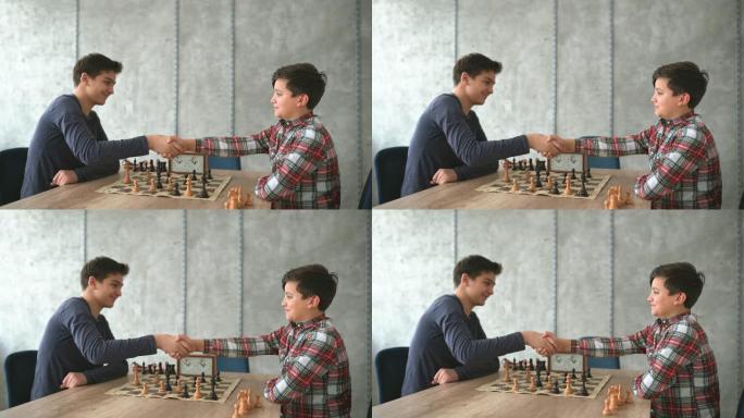 两个男孩下棋后握手