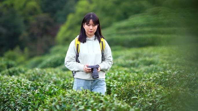 春天年轻女孩郊游公园拿相机拍摄美丽景色