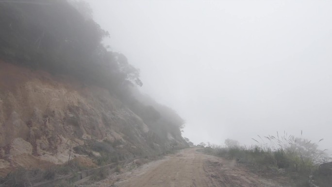 汽车行驶在能见度低的悬崖峭壁山路上