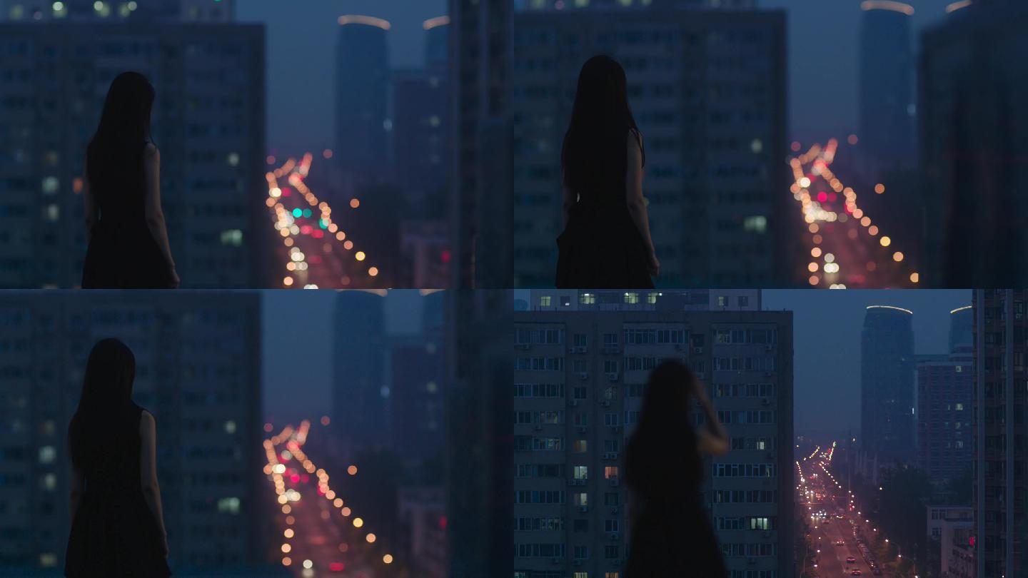黑衣长裙美女在天台眺望都市夜景