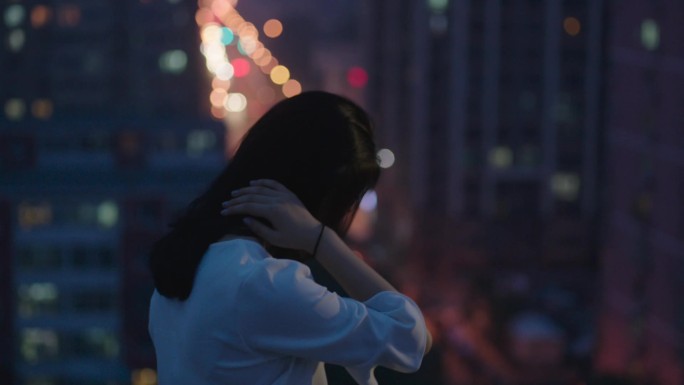 白衣长裙美女在天台眺望都市夜景