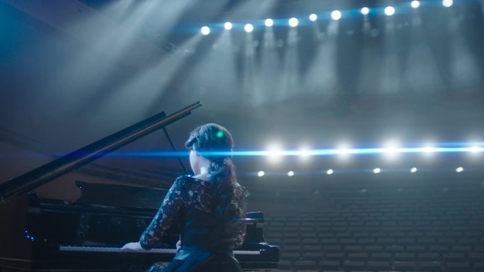 聚光灯下音乐厅弹钢琴的演员