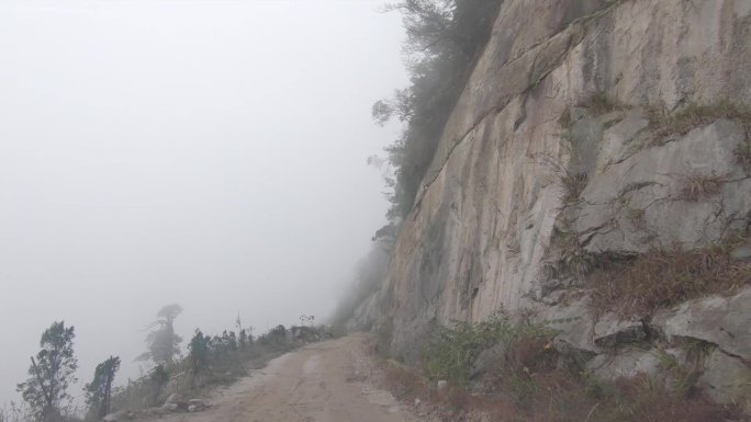 汽车行驶在能见度低的悬崖峭壁山路上