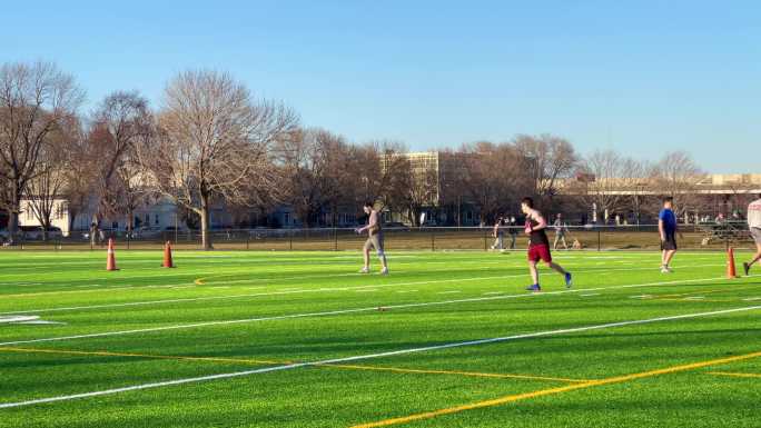 年轻人在足球场上练习踢足球