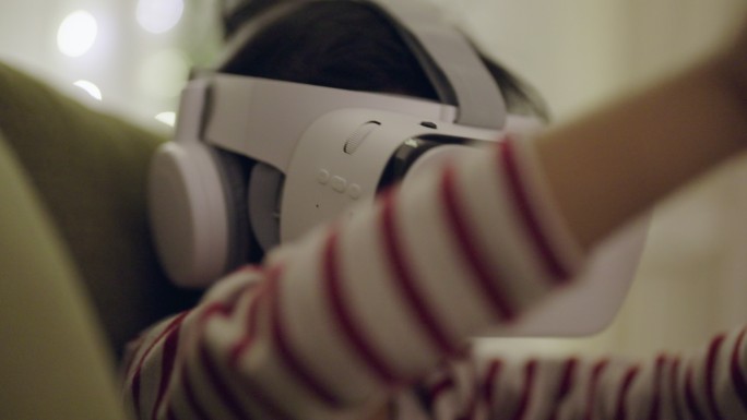 一个小男孩在家戴着虚拟现实耳机