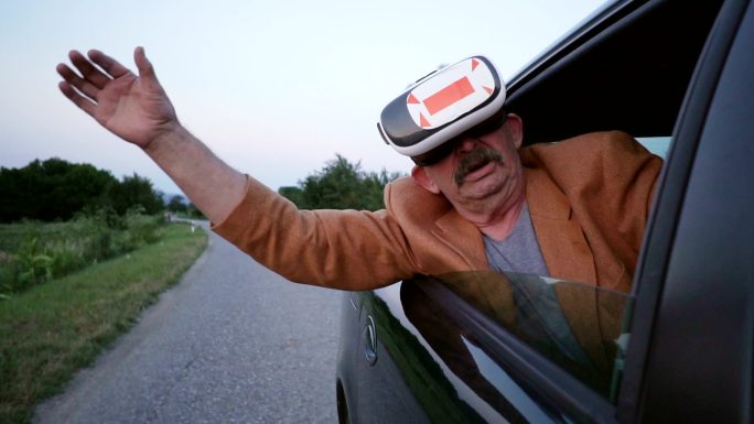 使用虚拟现实眼镜的老人探出车窗