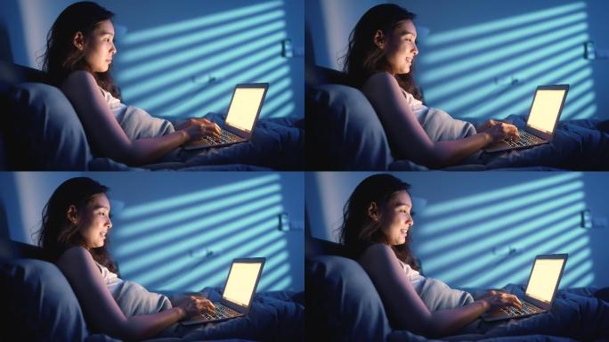 女性在夜间使用笔记本电脑浏览互联网