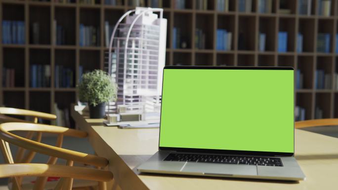 桌面上有一台绿色屏幕的笔记本电脑。