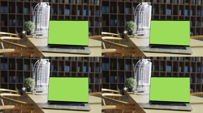 桌面上有一台绿色屏幕的笔记本电脑。
