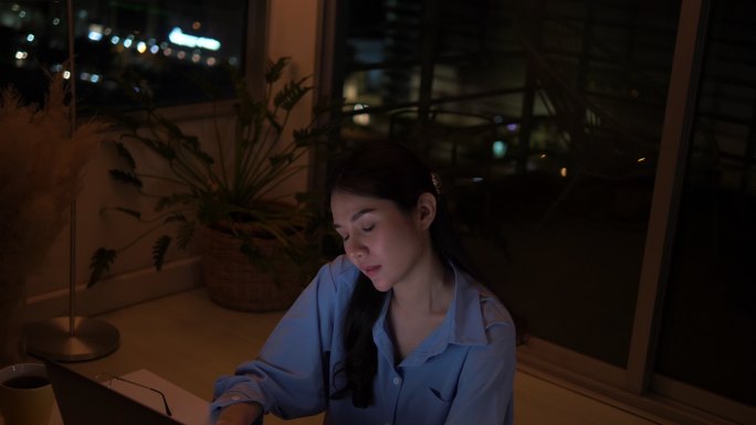 晚上在家办公室使用笔记本电脑的女性