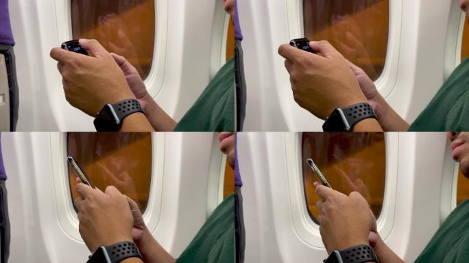 亚裔男子在飞机上使用智能手机