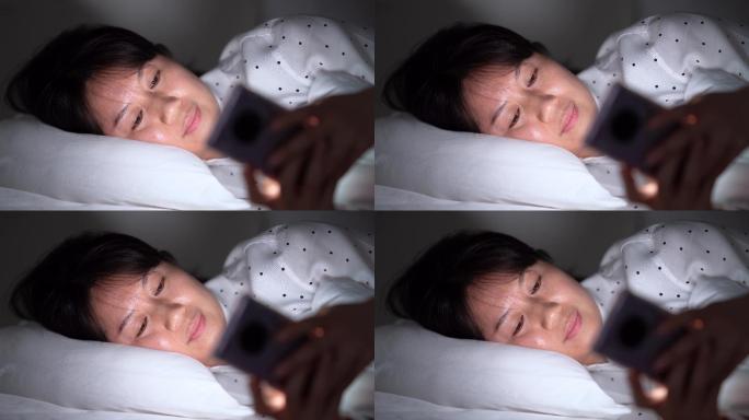 周末年轻女孩躺床上玩手机刷手机刷朋友圈