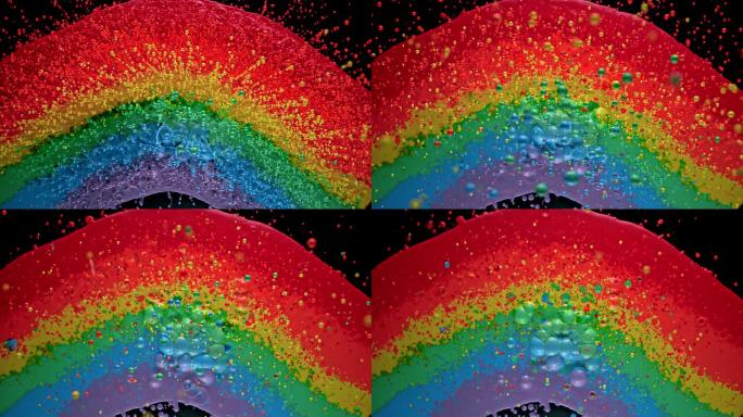 从彩虹般的色斑中飞向空中的彩色水滴的混合
