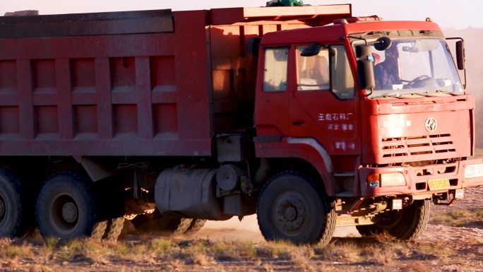 拉着泥土的大货车在沙地上运输