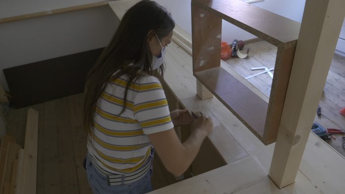 女人用木头组装厨房家具。
