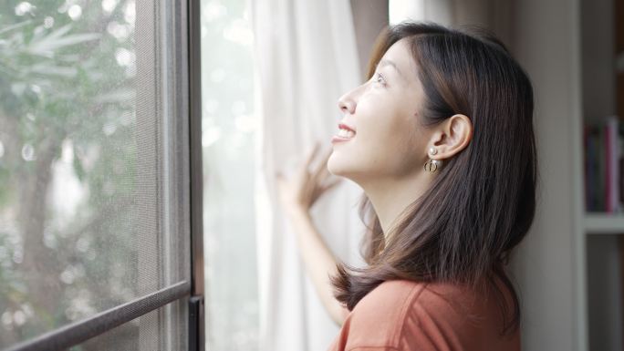 早上拉开窗帘看着窗外的女人