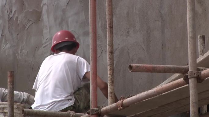 建筑工人瓦工正在往楼房上抹水泥