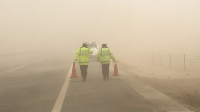 大风黄沙沙尘暴中保障路面逆行的交警